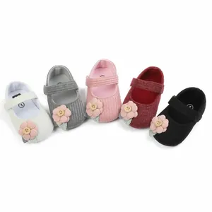 Bunte Strick-Babyschuhe für Mädchen mit Zierblumen und weichen Sohlen im Detail.