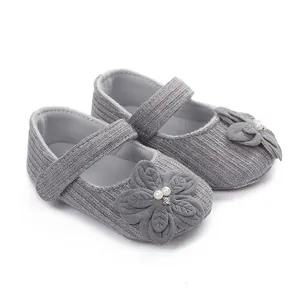 Dettaglio scarpe Mary Jane grigie per neonato con fiore decorativo in tessuto