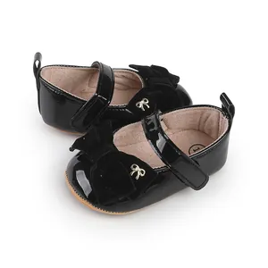 Detalle de zapatos de vestir negros de charol para bebé niña con lazo de terciopelo