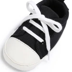 Detailansicht von schwarzen Baby-Leinenschuhen mit weißen Schnürsenkeln zum Laufen