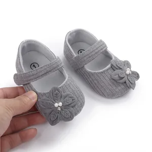 Dettaglio di scarpe Mary Jane grigie per neonata con eleganti fiori e decorazioni di perle