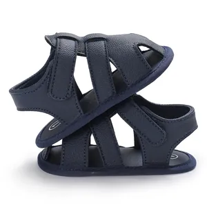 Gros plan de sandales bleu marine pour bébé avec cuir PU texturé et brides velcro.