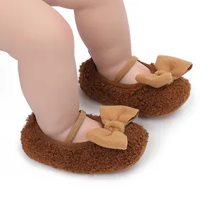 Detalle de zapatos de bebé de felpa marrón con suelas blandas y lazos decorativos