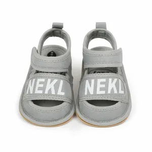 Gray soft fabric baby walking sandals with NEKL print and Velcro straps for infants