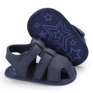 Détail de sandales bleu marine pour bébé avec une semelle souple antidérapante à étoiles
