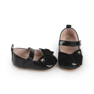 Primer plano de zapatos de princesa para bebé en charol negro con lazo de terciopelo
