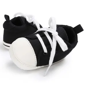 Detaillierte Nahaufnahme der schwarz-weißen Baby-Laufschuhe aus Segeltuch zum Schnüren