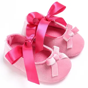Chaussures bébé en velours rose avec grands rubans de satin et nœuds