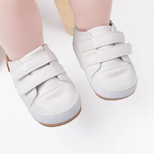 Close-up view of white baby toddler walking shoes featuring double hook-and-loop straps