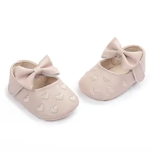 Nahaufnahme von Baby-Lernlaufschuhen mit Herzbestickung und dekorativer Schleife