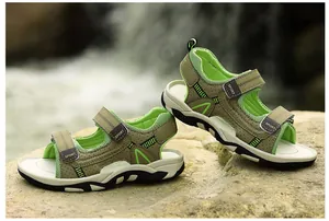 Macro detail view of kids' outdoor breathable sport sandals with green accents on a rock.