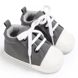 Detailansicht grauer Baby-Lauflernschuhe aus Canvas mit weißen Schnürsenkeln.