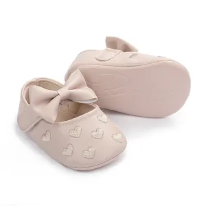 Detailaufnahme von rosa Baby-Prinzessin-Schuhen mit eleganter Schleife und Herzen.