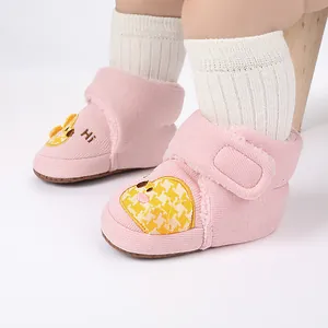 Detailansicht der rosa gestrickten Baby-Winterschuhe mit süßem gelben Küken-Patch