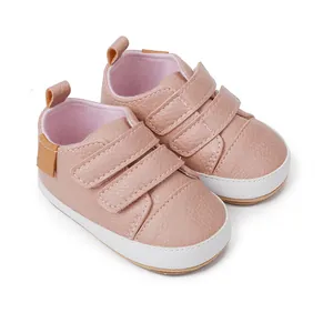 Close-up detail of pink faux leather baby walking shoes with triple velcro straps