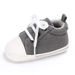 Detail eines grauen Baby-Leinenschuhs mit weißen Schnürsenkeln und weicher Sohle