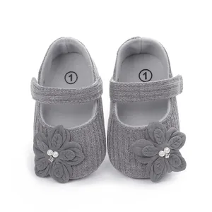 Dettaglio scarpine da principessa per neonata in maglia grigia con fiori e perle decorative
