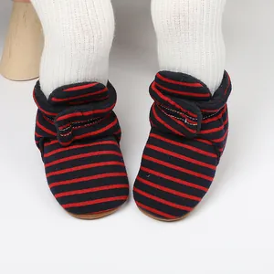 Gros plan sur des bottes de marche d'hiver pour bébé à rayures bleu marine et rouges