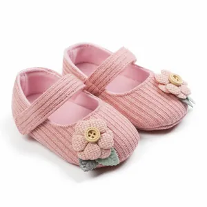 Detailansicht rosa gestrickte Babyschuhe für Mädchen mit Blumen- und Knopfakzenten