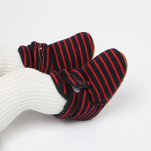 Gros plan de bottines d'hiver rayées pour bébé avec doublure polaire et velcro