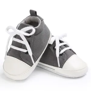 Detailansicht von grauen Baby-Leinenschuhen mit weißen Schnürsenkeln und Zehenkappen.