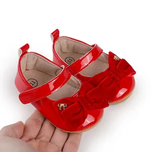 Primer plano de zapatos de princesa para bebé en charol rojo con lazo de terciopelo