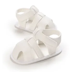 Gros plan de sandales blanches pour bébé avec semelle souple et texture cuir synthétique