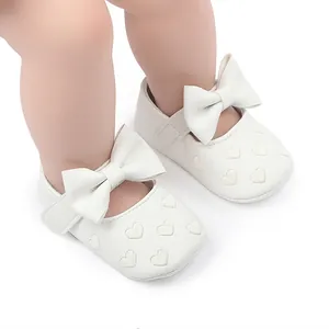 Detailansicht der weißen Baby-Lauflernschuhe mit Herzmuster und Schleifendekorationen