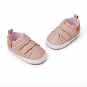 Detailed macro view of pink faux leather baby walking shoes with dual Velcro strap closures