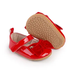 Vista detallada de zapatos rojos de princesa para bebé con lazo de terciopelo.
