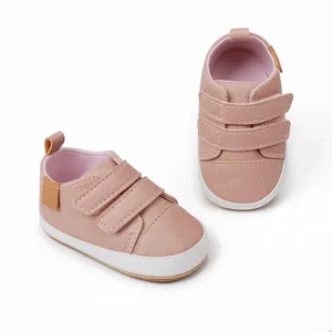 Detailed view of pink faux leather baby walking shoes with white soles and Velcro straps