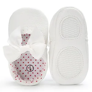 Vista detallada de zapatos de princesa para bebé blancos con lazo y suela antideslizante