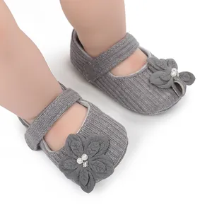 Vista dettagliata di scarpe da principessa per neonati in maglia grigia con fiori e perle