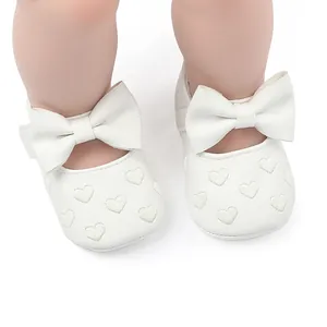Detailansicht weißer Baby Prinzessinnenschuhe mit Herzstickerei und großer Schleife