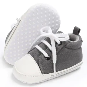 Detailansicht grauer Canvas-Babyschuhe mit Schnürung und rutschfester weißer Sohle