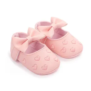 Nahaufnahme weicher rosa Baby-Prinzessinnen-Lauflernschuhe mit Schleife und Herzstickerei