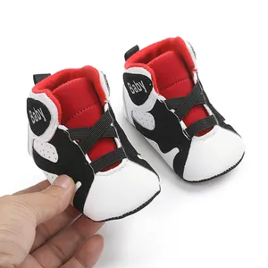 High-quality close-up of soft-sole baby basketball sneakers featuring red and white colors