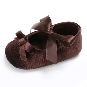 Vue détaillée en gros plan d'une chaussure pour bébé en velours avec nœuds en satin