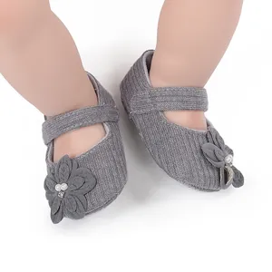 Dettaglio di scarpe primi passi grigie per neonati con fiori e perle per uso interno