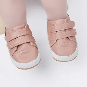 Close-up detail of soft pink baby pre-walker sneakers featuring double velcro straps