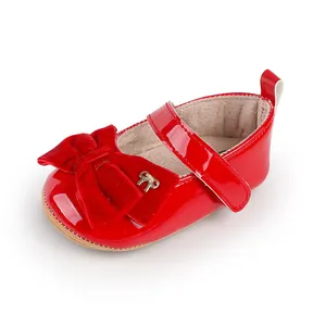 Detalle de zapato de princesa rojo para bebé en charol con lazo de terciopelo