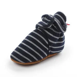 Vue détaillée montrant la texture des chaussures de marche bébé en polaire à rayures