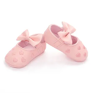 Nahaufnahme rosa Baby-Prinzessinnenschuhe mit Schleife und gestickten Herzmustern