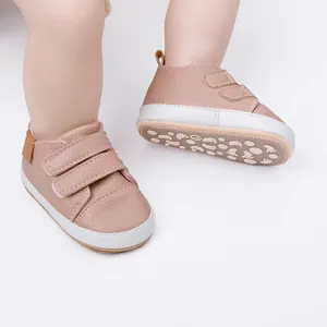 Soft pink baby walking shoes with velcro straps and anti-slip sole pattern details.