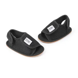 Detailaufnahme schwarzer, atmungsaktiver Mesh-Babysandalen mit Klettverschluss und Etikett
