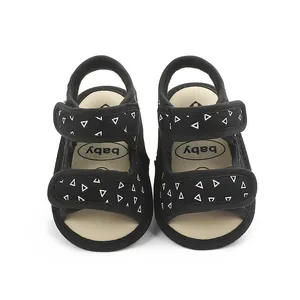 Soft-soled black baby walking sandals with white triangle pattern and double Velcro straps