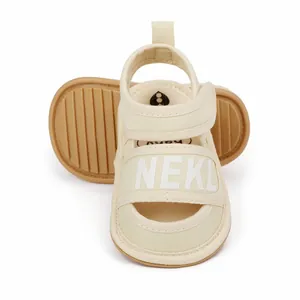 Detailed view of beige infant sandals with NEKL branding and anti-slip sole pattern
