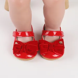 Vista detallada de zapatos de princesa de charol rojo para bebé con lazos de terciopelo