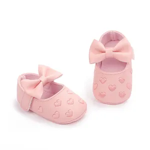 Nahaufnahme von rosa Baby-Prinzessin-Schuhen mit 3D-Schleife und Herzstickerei