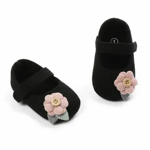 Detailansicht der schwarzen Baby-Mädchen-Schuhe mit weicher Sohle und rosa Blumen